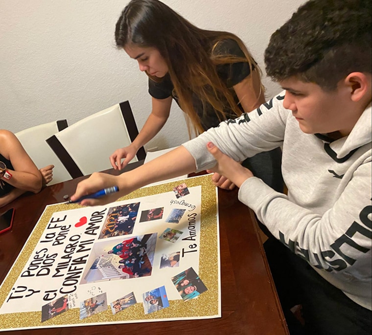 Mariana y Gerónimo Rodríguez, hijos de Sol y Hernando, construyen una pancarta para su padre en la sala de su casa en Doral, Florida, febrero de 2021.