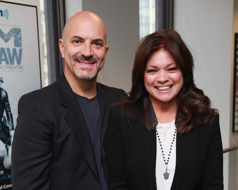 Tom Vitale and Valerie Bertinelli smile for a photo, both in business casual black blazers.