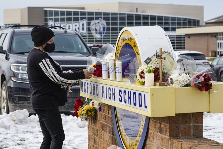 Image: A well wisher leaves a stuffed animal at a memorial on the sign of Oxford High School in Oxford, Mich., Dec. 1, 2021.