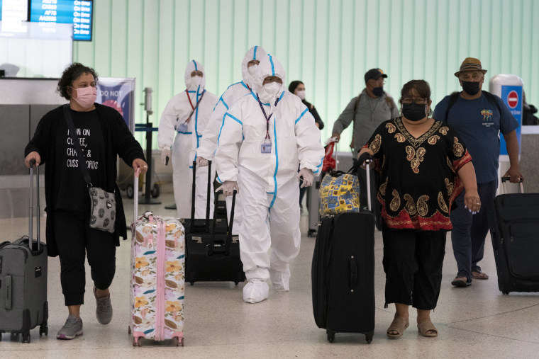 Air China flight crew members in hazmat suits walk through the arrivals area at the Los Angeles International Airport on Tuesday.