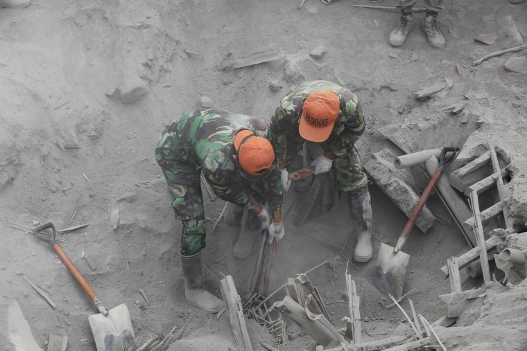 Soldiers search for victims in a location where a house is buried beneath volcanic ash from the eruption of Mount Semeru in Candi Pure village, Lumajang, East Java, Indonesia, on Dec. 7, 2021.