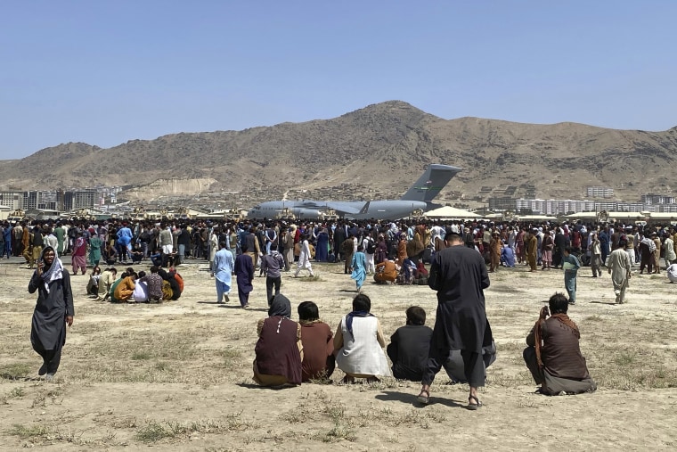 Hundreds of people gather near a U.S. Air Force C-17 transport plane at the international airport in Kabul, Afghanistan, on Aug. 16, 2021. 
