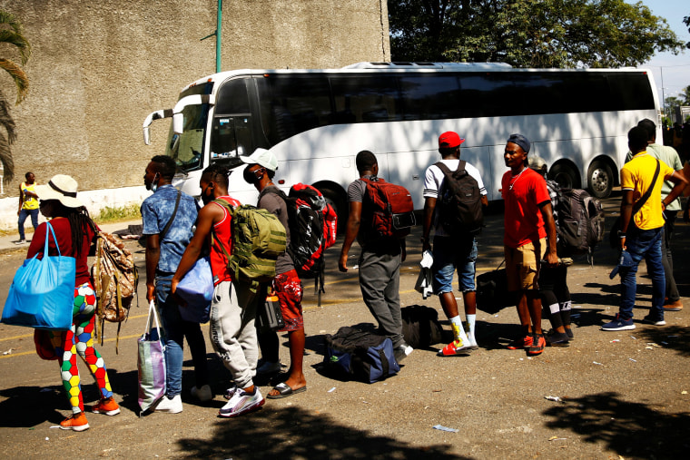 Migrants line up to board a bus after accepting an offer from the Mexican government to obtain humanitarian visas to transit through Mexican territory, in Tapachula on Dec. 5, 2021.