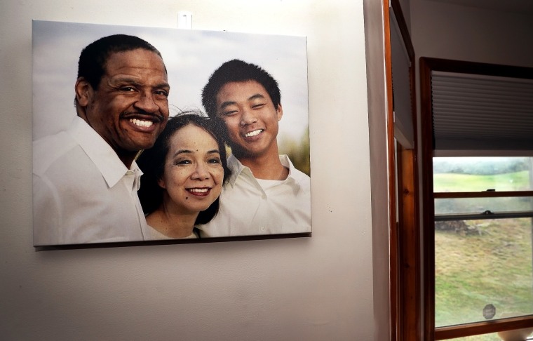 Image: A family portrait of Gareth, Fe and Christian Hall hanging on the wall.