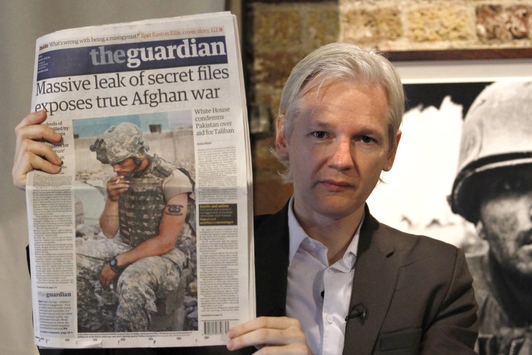 Wikileaks founder Julian Assange holds up a copy of the Guardian newspaper during a press conference at the Frontline Club in central London