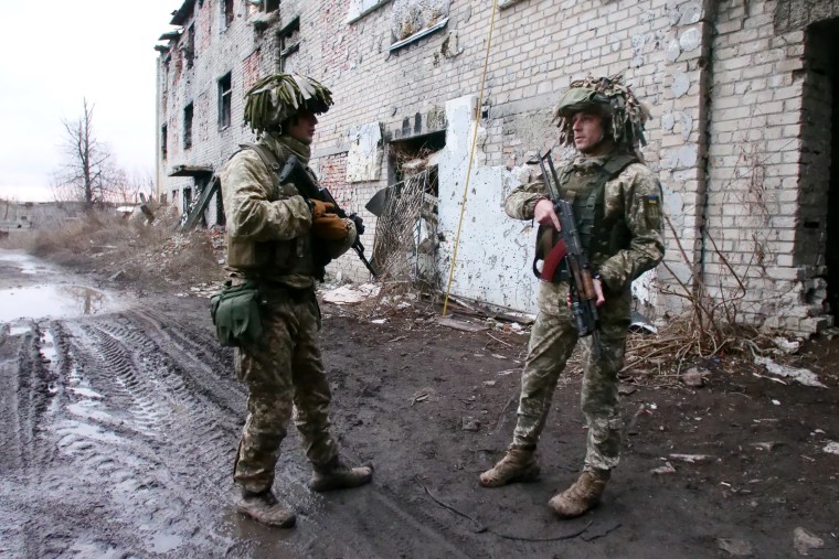 Ukrainian soldiers talk near a front-line position in Avdiivka, about 50 yards from pro-Russian separatists in Donetsk.