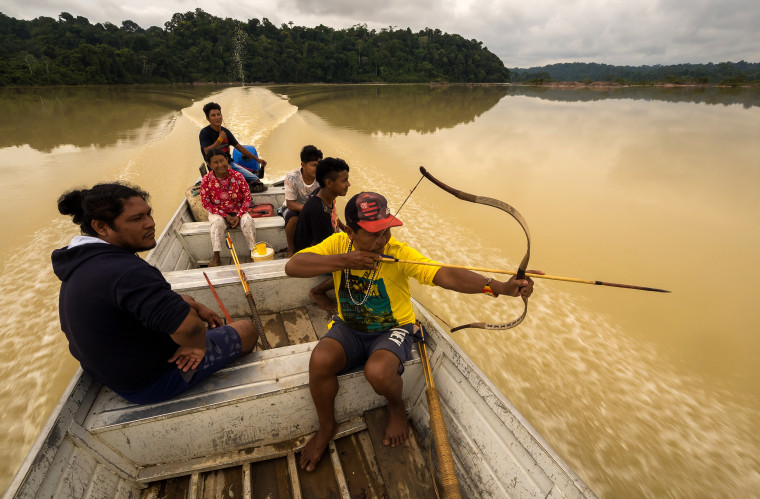 Image: Chief Juarez Munduruku tests his bow while riding along the Rio Jamanxim to check on reports of illegal timber cutting on tribal lands.