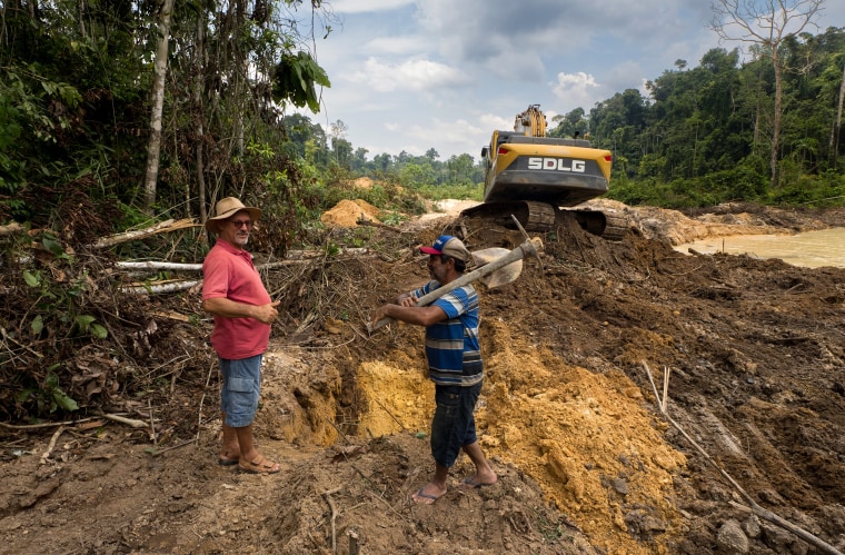 Image: Odacir "Gringo" Leseux, left, speaks to a miner at the Boa Esperanca gold-mining operation in the jungles outside of Itaituba, Brazil.