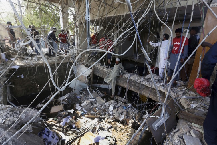 Rescuers inspect the scene of a gas explosion in Karachi, Pakistan, Saturday, Dec. 18, 2021.