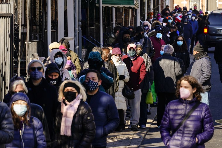 City residents wait in a line extending around the block to receive free at-home rapid Covid-19 test kits in Philadelphia on Dec. 20, 2021.