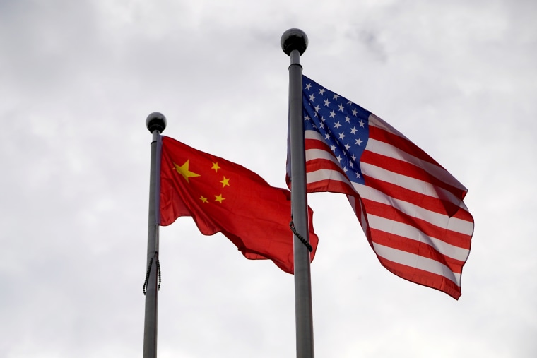 Chinese and U.S. flags flutter outside a company building in Shanghai
