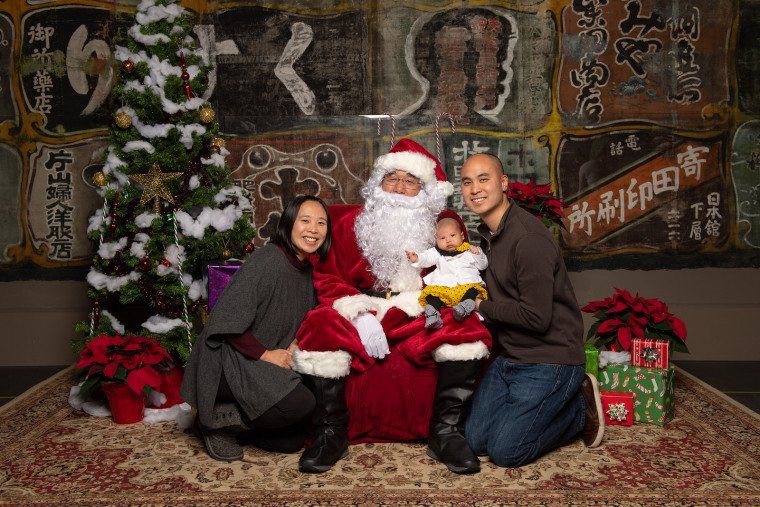 A family poses with Al Young dressed as Santa at Seattle's Wing Luke Museum in 2019.