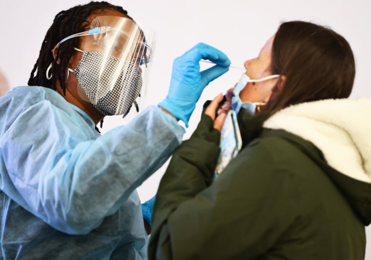A health worker administers a Covid-19 test at Los Angeles International Airport on Dec. 21, 2021.