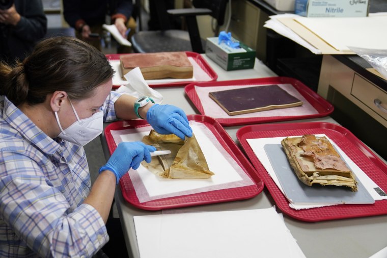 Sue Donovan, conservator for Special Collections at the University of Virginia, works on an envelope that was removed from a time capsule that was found underneath the statue of Confederate General Robert E. Lee on Dec. 22, 2021, in Richmond, Va.