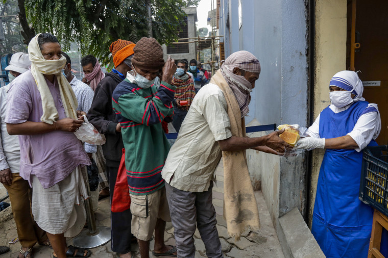 Nuns of Missionaries of Charity distribute food to the poor and needy in Kolkata on Tuesday. 