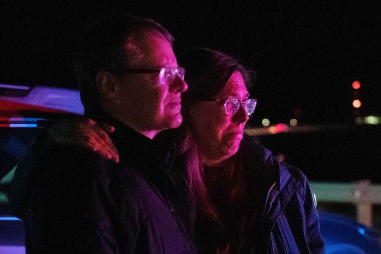Image: Dr. Bonnie Abbott embraces her husband George as they watch flames engulf homes as the Marshall Fire spreads through a neighborhood in Superior, Colo., on Dec. 30, 2021.