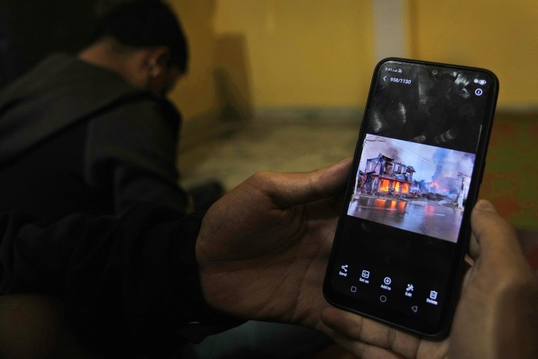 Myanmar refugees who have fled from violence in Chin state, northwestern Myanmar, watch photos and videos of the violence at an undisclosed location, in India, on Dec. 13. 