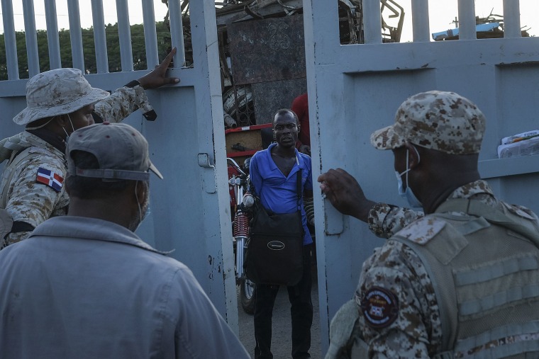 Soldados de República Dominicana cierran una puerta fronteriza a un hombre haitiano que esperaba cruzar a Dajabón, República Dominicana, el viernes 19 de noviembre de 2021.
