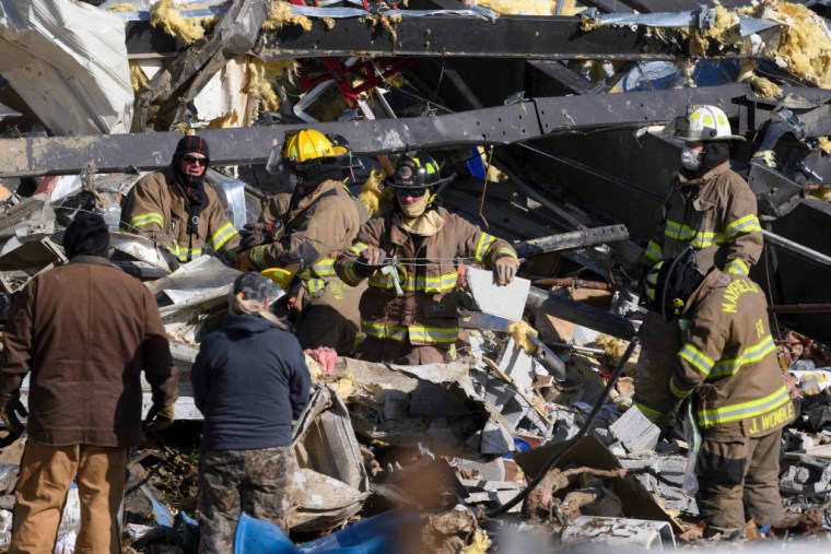 Rescatistas trabajan entre los escombros de una fábrica de velas en Mayfield, Kentucky, después del paso de los tornados el 11 de diciembre de 2021.