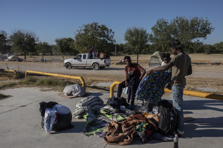 Un grupo de migrantes se aleja en la parte trasera de un camión en un campamento después de aceptar ser trasladado a un refugio, en Ciudad Acuña, México, el viernes 24 de septiembre de 2021, al otro lado del río Grande desde Del Río, Texas.