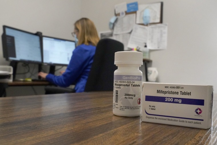 Una enfermera realiza una videollamada con una paciente que requiere pastillas abortivas en una oficina en una clínica de Planned Parenthood. Sobre la mesa, hay un paquete de píldoras de mifepristona.