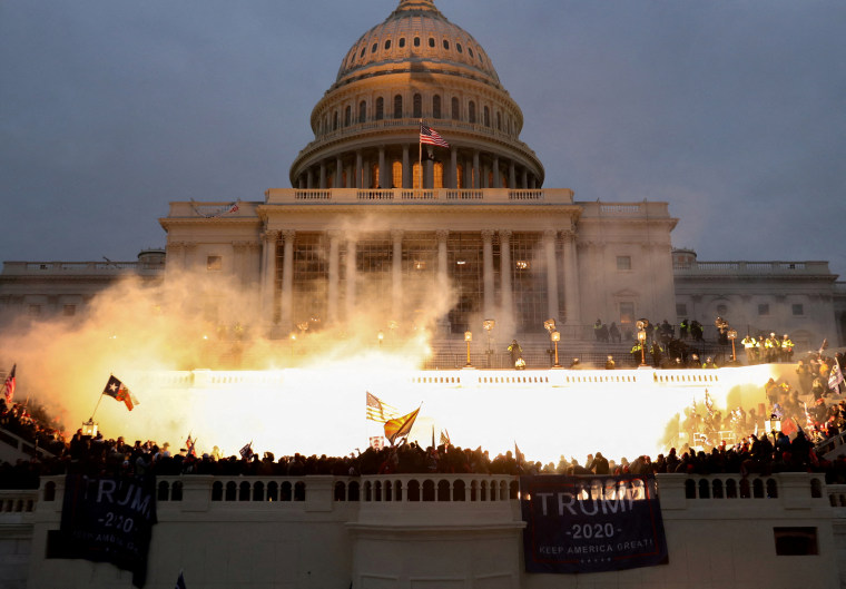 Una explosión causada por una munición de la policía se ve mientras los partidarios del expresidente Donald Trump se amotinan frente al edificio del Capitolio, el 6 de enero de 2021.