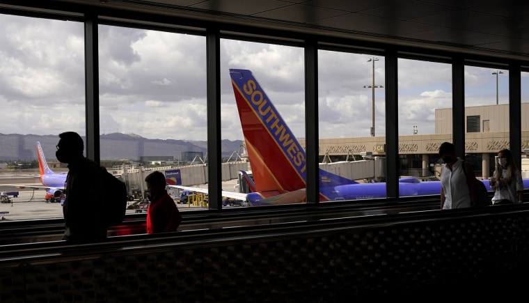 Los pasajeros pasan frente a un avión de Southwest Airlines en el Aeropuerto Internacional Sky Harbor en Phoenix, el 26 de marzo de 2021.