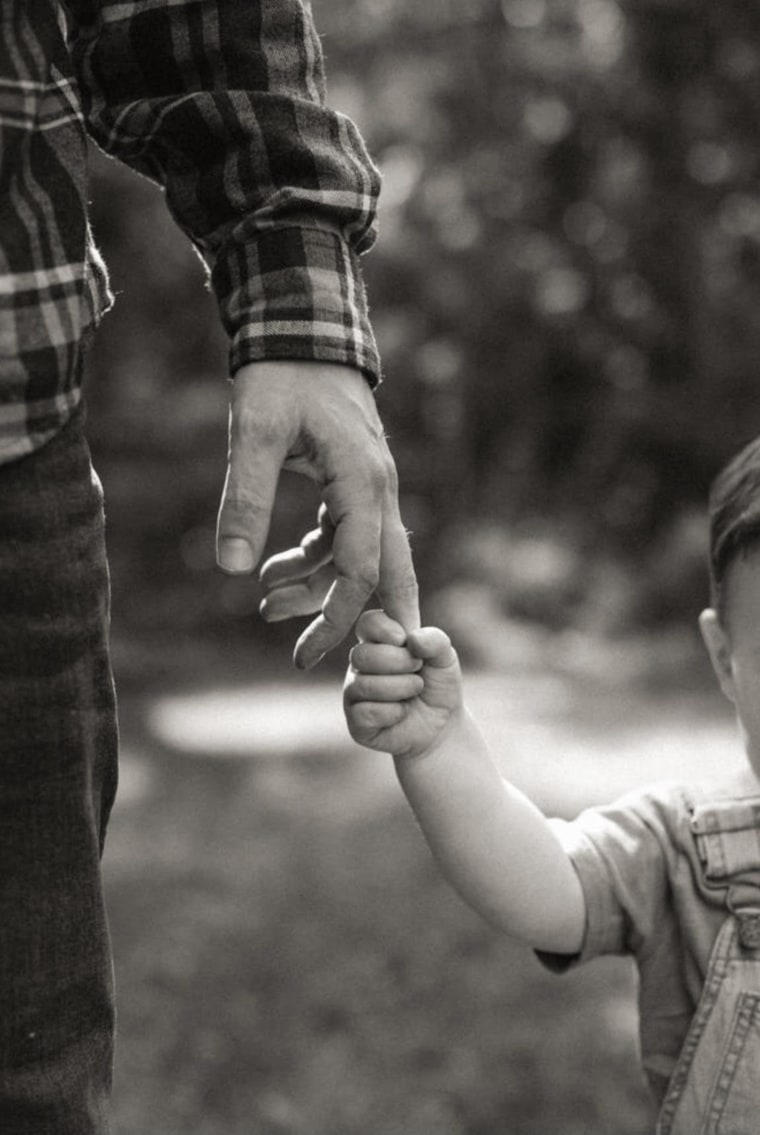 Jb Parke holds hands with his firstborn son.