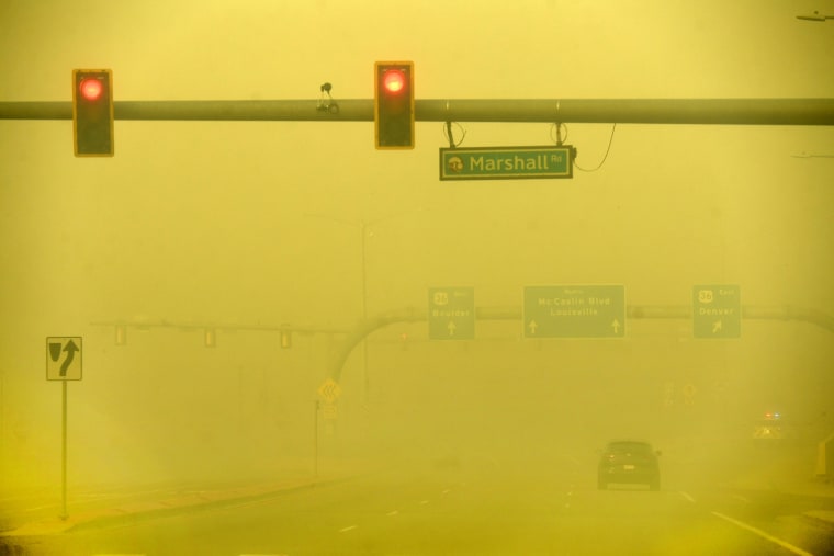 A car makes its way down Colorado's McCaslin Blvd. amid a smoky, yellow sky.