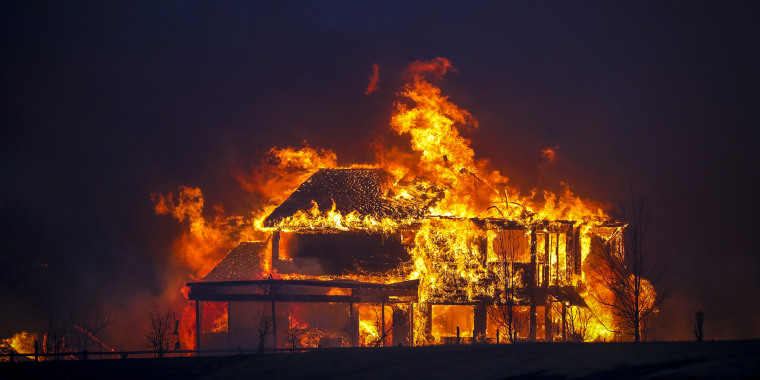 A home burns after a fast moving wildfire swept through the Centennial Heights neighborhood of Louisville, Colorado, on Dec. 30, 2021. 