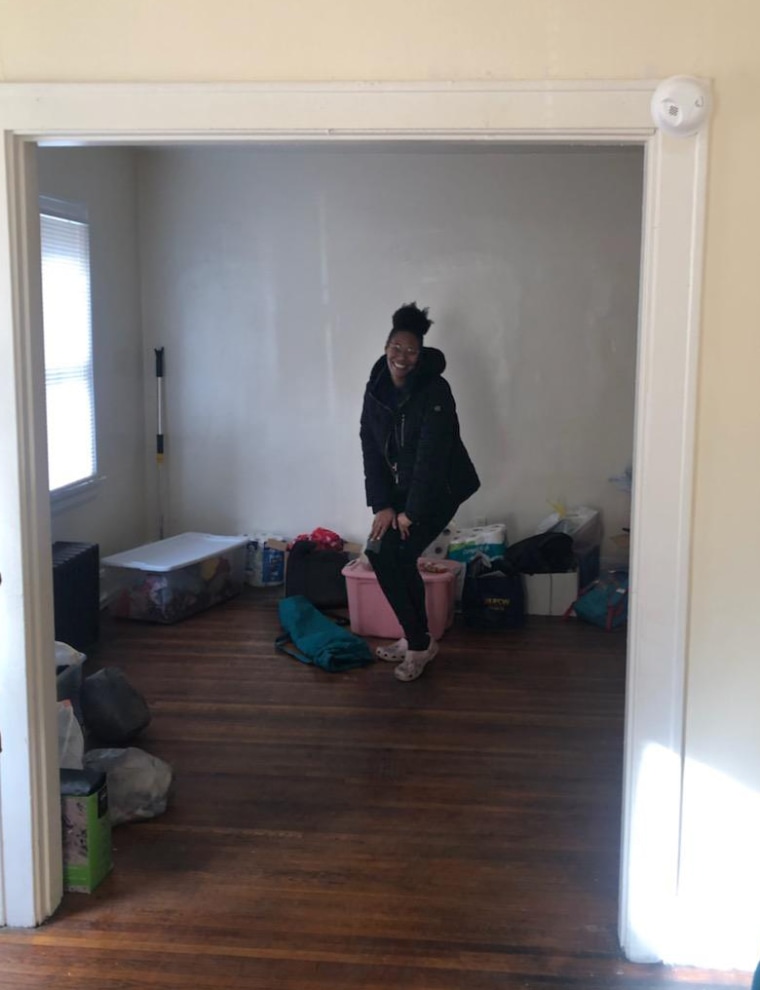 Ebony Johnson smiles as she moves her family's belongings into the new apartment.