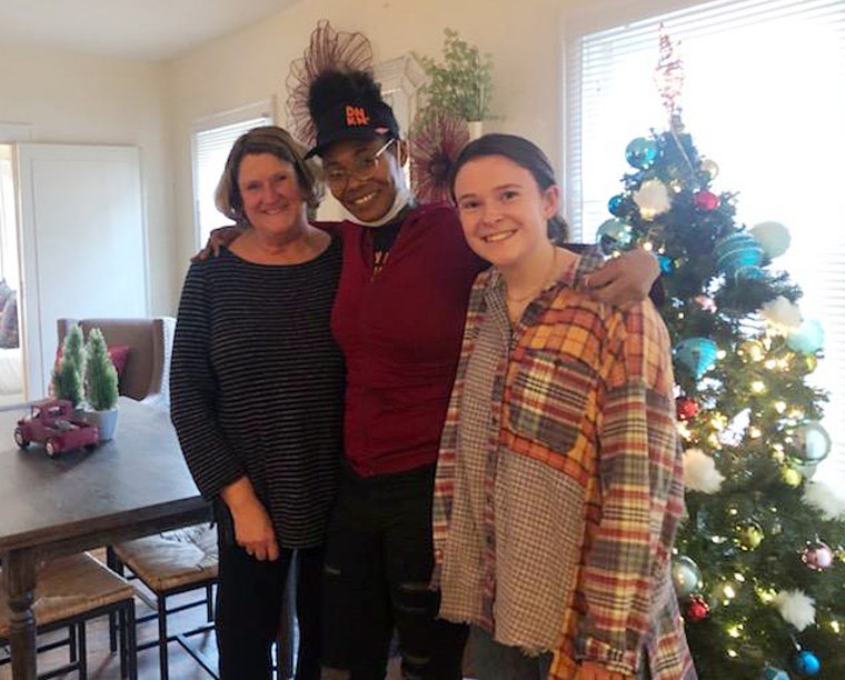 Suzanne Burke (left) and her daughter (right) celebrate Ebony Johnson (middle) moving into her new apartment just in time for Christmas.