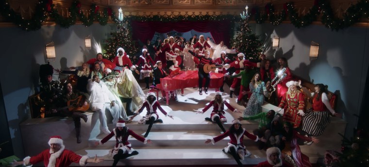 Elton John and Ed Sheeran sing around dancers and extras in their "Merry Christmas" music video.