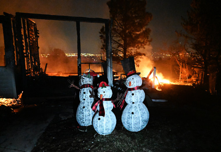 Christmas decorations stand outside a home destroyed by the fire.