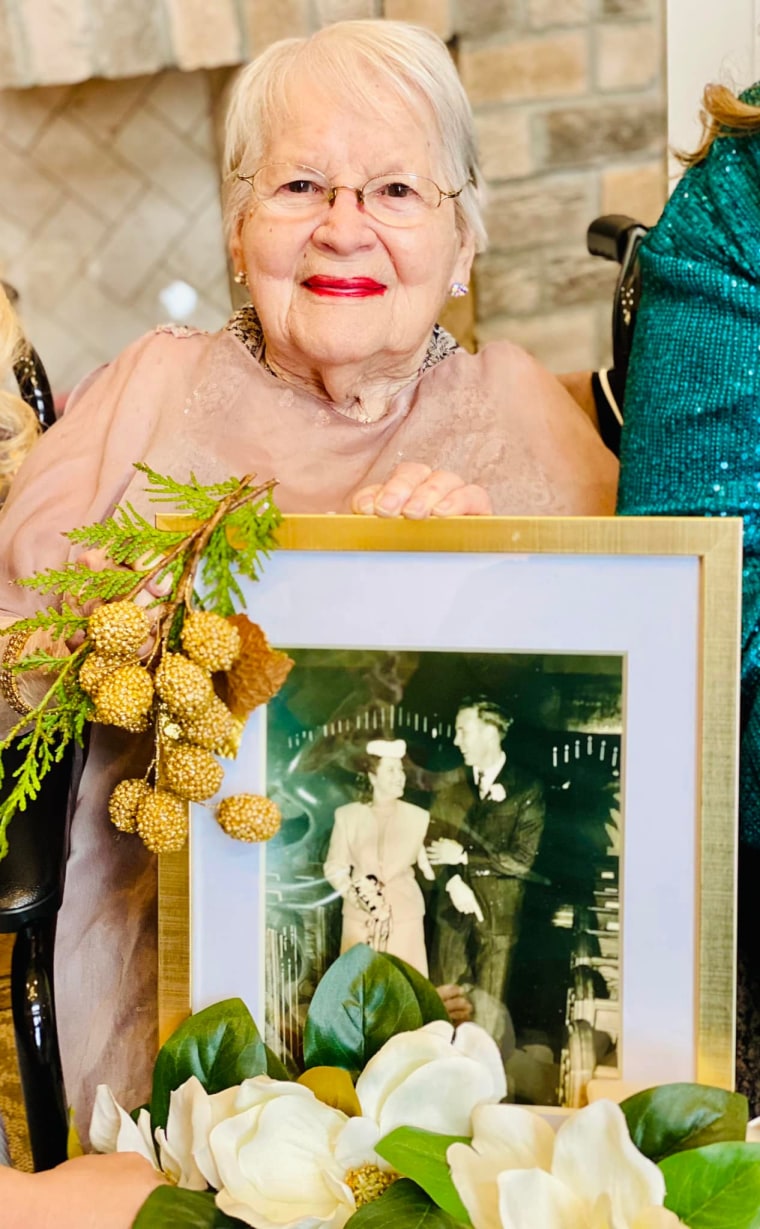 Courtney holds up a framed photo from her own wedding to her late husband, Paul, in 1947.