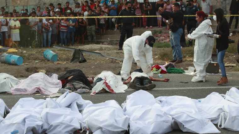 Cuerpos en bolsas para cadáveres se colocan a un costado de la carretera después del accidente el 9 de diciembre de 2021.