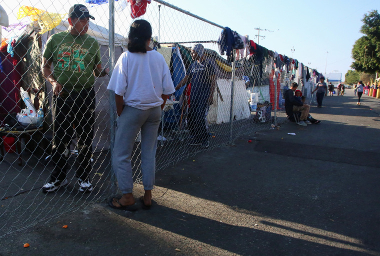 Migrantes centroamericanos, a la espera de solicitar asilo en Estados Unidos, permanecen en un campamento cerca del cruce fronterizo de El Chaparral en Tijuana, México, 5 de diciembre de 2021. 