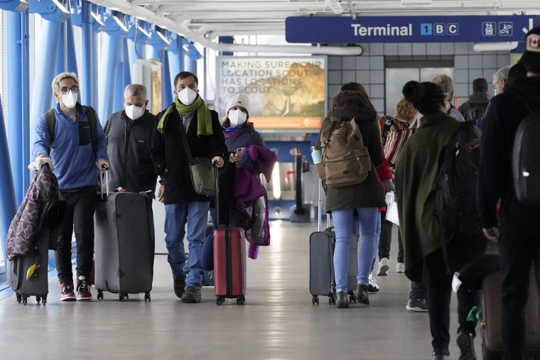 Travelers walk through Terminal 1 at O'Hare International Airport in Chicago on Dec. 30, 2021.