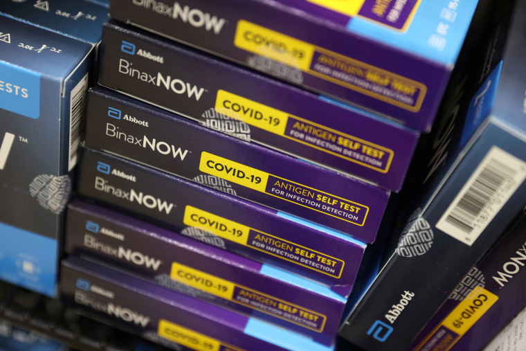 Image: Packages of Abbott Laboratories' BinaxNOW Covid-19 Antigen Self Test are stacked on a shelf in a store in N.Y., on Nov. 12, 2021.