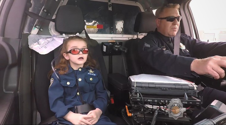 Olivia Gant rides with Cpt. Tim Scudder on a call in Denver in 2017,  after police made her an officer for a day. 