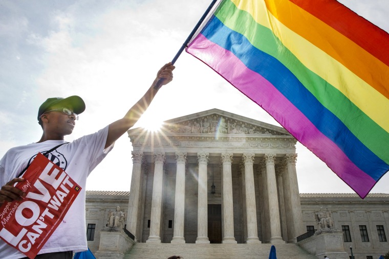 Carlos McKnight of Washington, waves a flag in support of gay marriage outside of the Supreme Court on June 26, 2015.