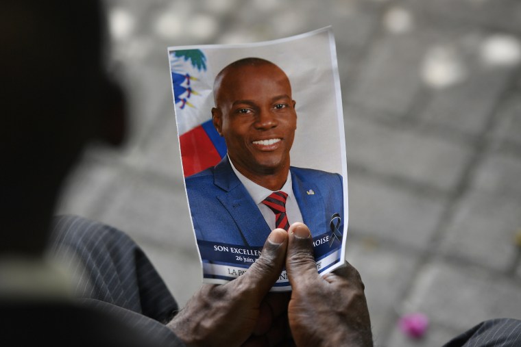 A mourner holds a photo of late Haitian President Jovenel Moise during his memorial ceremony at the National Pantheon Museum in Port-au-Prince on July 20, 2021.