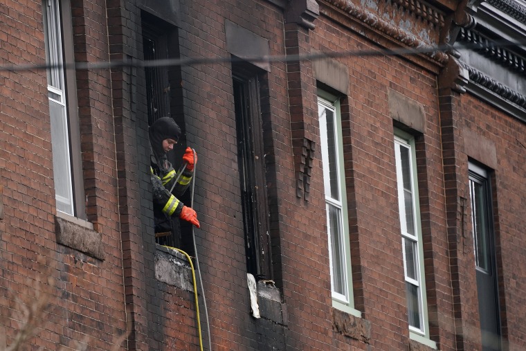 Image: A firefighter works at the scene of a deadly row house fire in the Fairmount neighborhood of Philadelphia on Jan. 5, 2022.