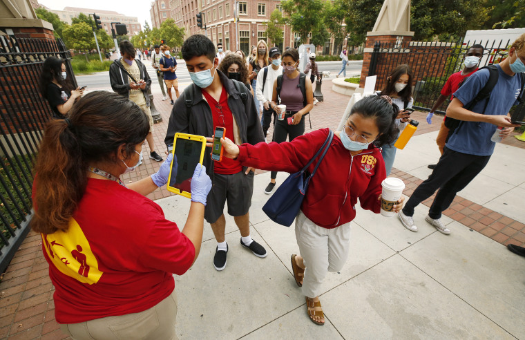 USC students, faculty and visitors use their phones to display their "Trojan Check" QR code in order to access the USC campus on Aug. 23, 2021, in Los Angeles.