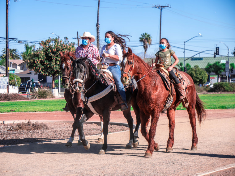 A father and his two daughters ride into a cabalgata on March 28, 2021.