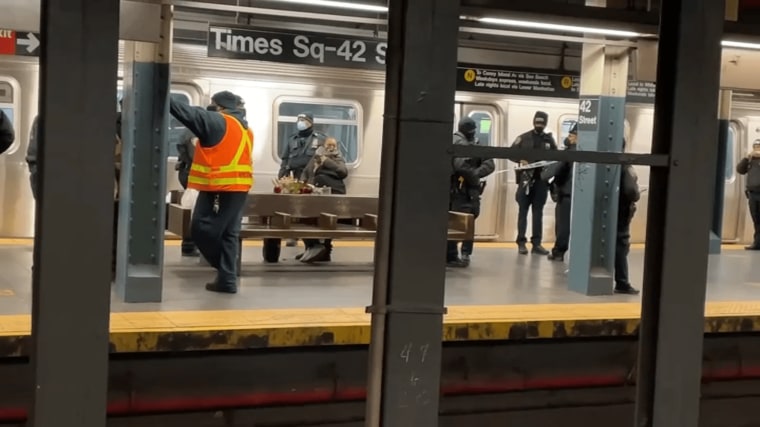 Police and transit crew members investigate a deadly assault on a Times Square subway platform.