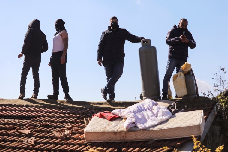 Image: Palestinians take to the roof and threaten to blow-up the building of a home in the flashpoint Sheikh Jarrah neighbourhood of East Jerusalem