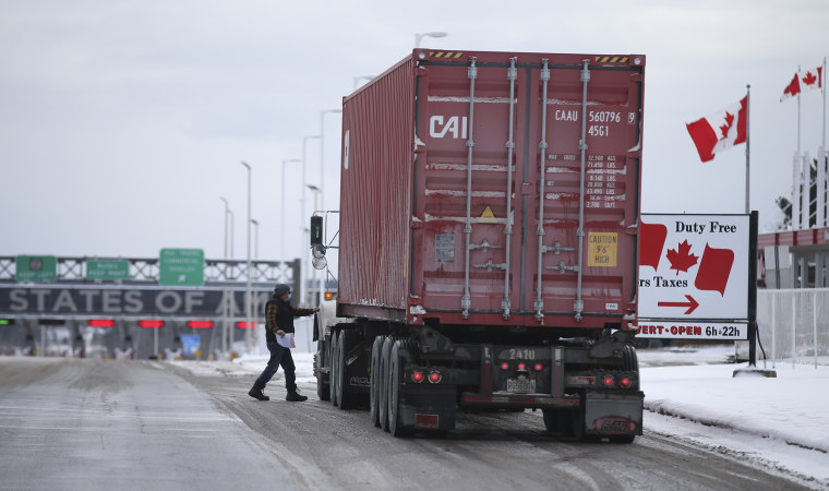 Image: A driver heads back to his truck after stopping at Canadian Customs heading towards the U.S. at the border in St-Bernard-de-Lacolle, Quebec, Canada, on Friday, Jan. 14, 2021.