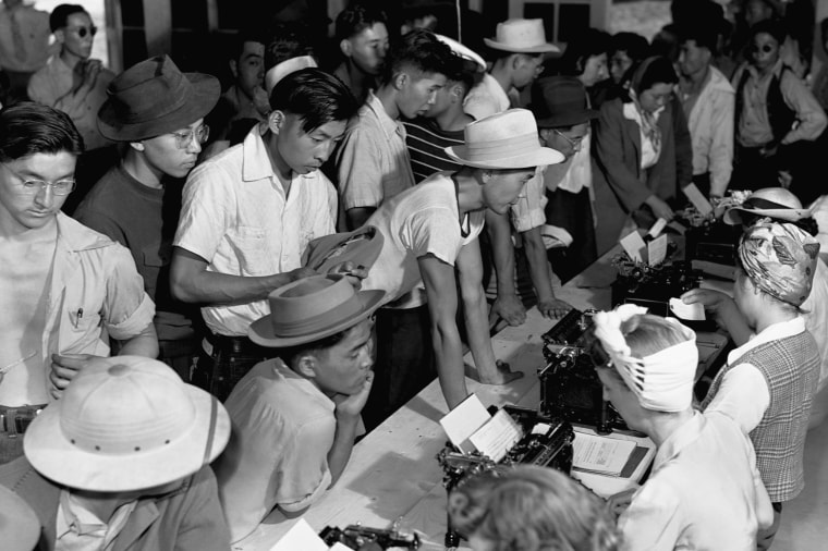 Japanese Americans deal with paperwork at an internment camp in the early 1940s.