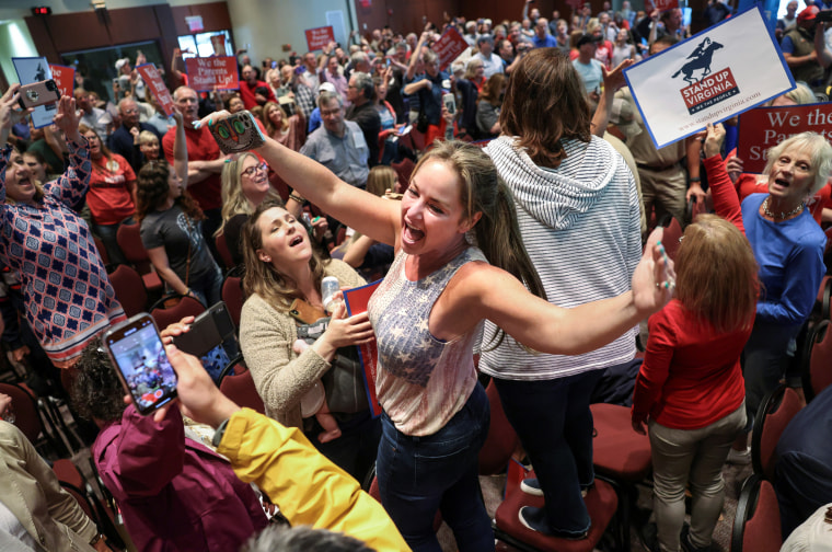 Image: Elicia Brand leads a crowd of parents and community members singing the Star Spangled Banner at a Loudoun County School Board meeting in Va., on June 22, 2021. Local school boards in the state criticized critical race theory teachings.